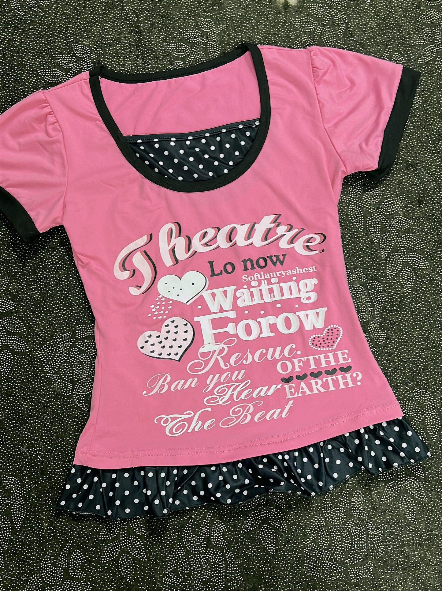 Pink youth T-shirt with black neckline trim, heart letter graphic and polka-dot ruffle