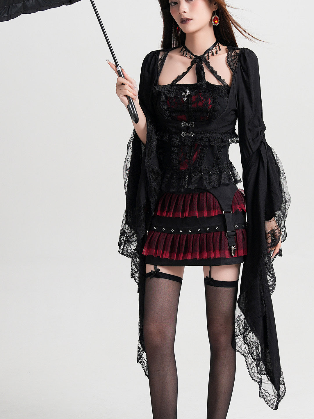 Black cropped lace coat with long flared sleeves and lace-cuff panels over dress.