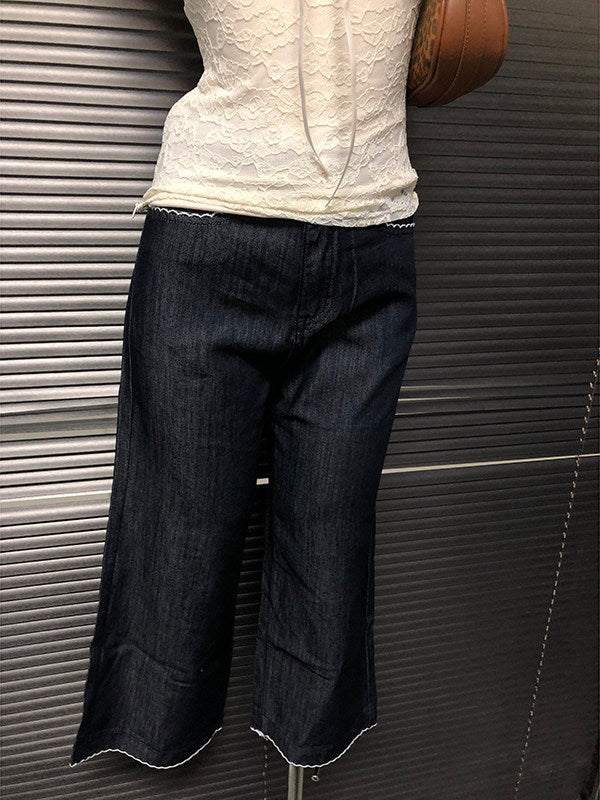 Dark blue cropped flare jeans with angled front pockets and scalloped hem
