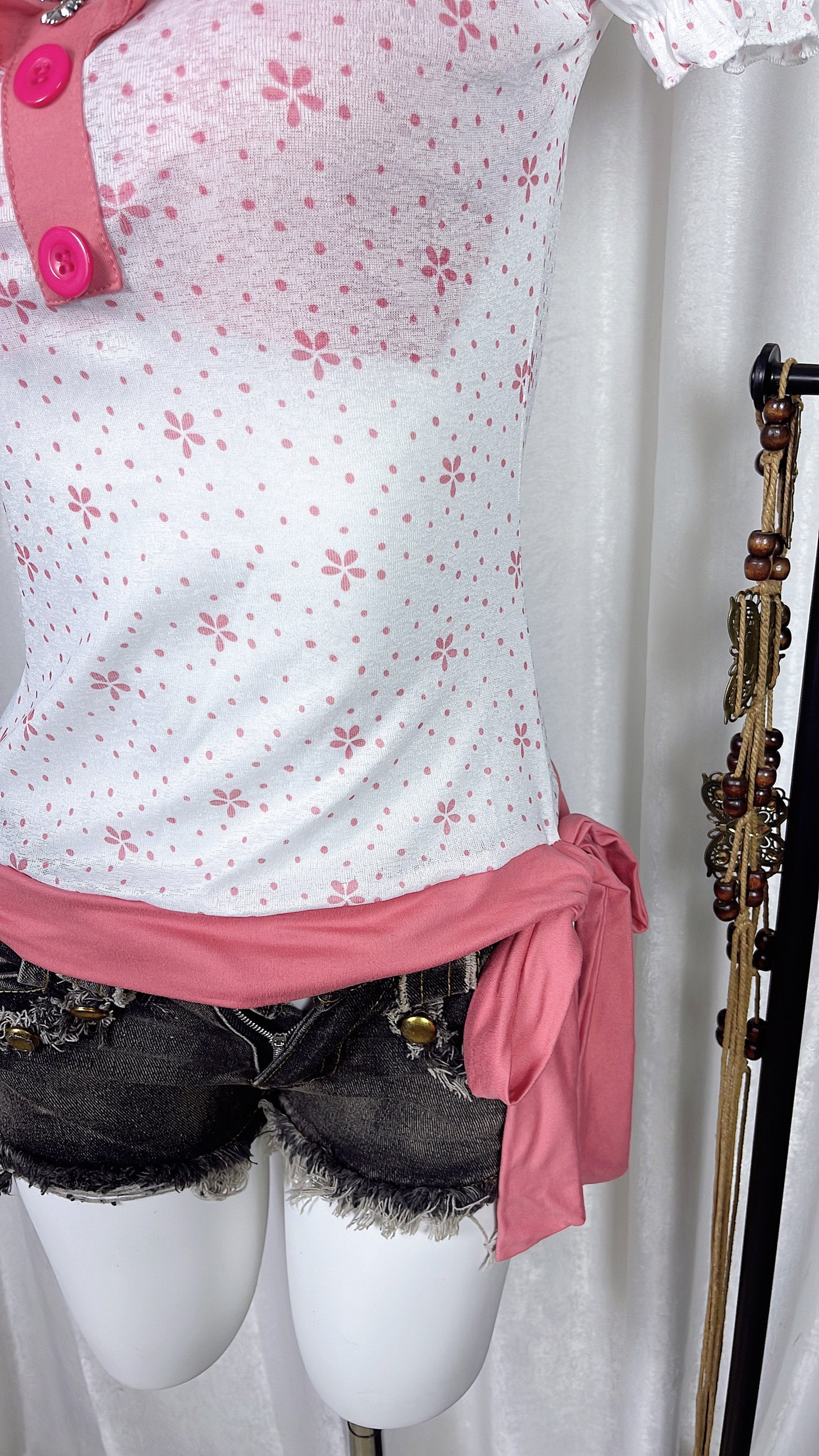 Pink flower print top front with pink ruffle hem and buttoned placket