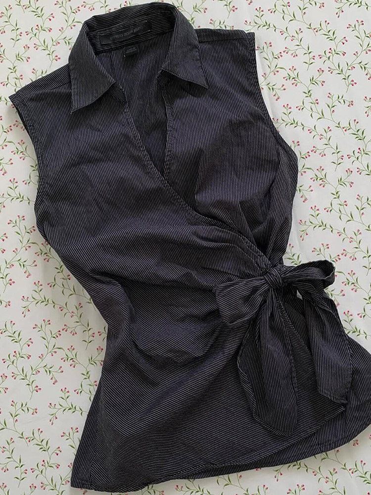 Black sleeveless cardigan top with V-neck front and tied waist bow, flared hem