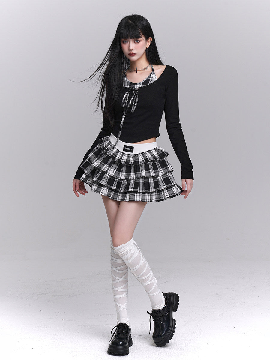 Black long-sleeve cropped top with plaid bow-tie neckline and tiered check skirt