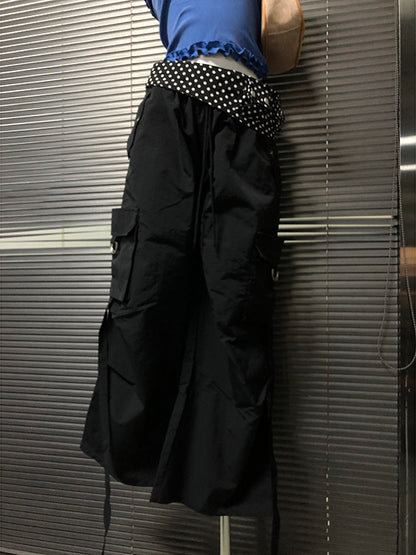 Black wide-leg pants detail: white polka-dot waistband band