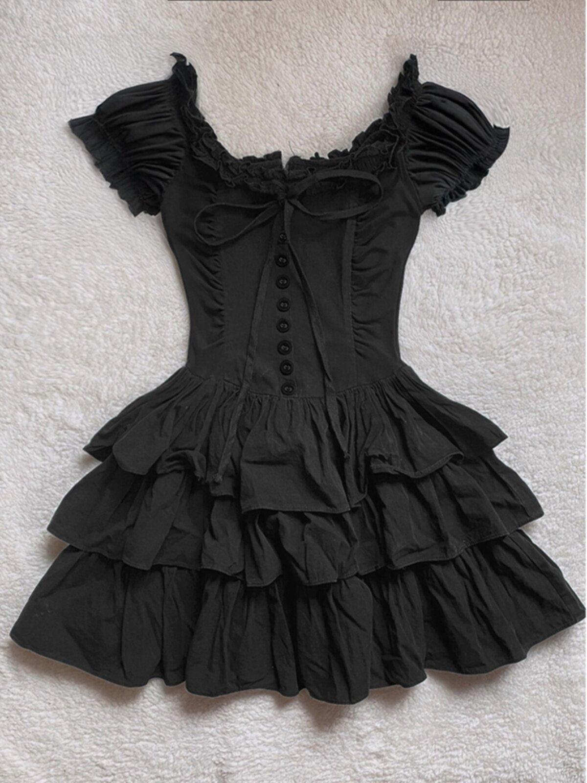 Black off-shoulder ruffle cake dress with corset-style button placket and tiered skirt