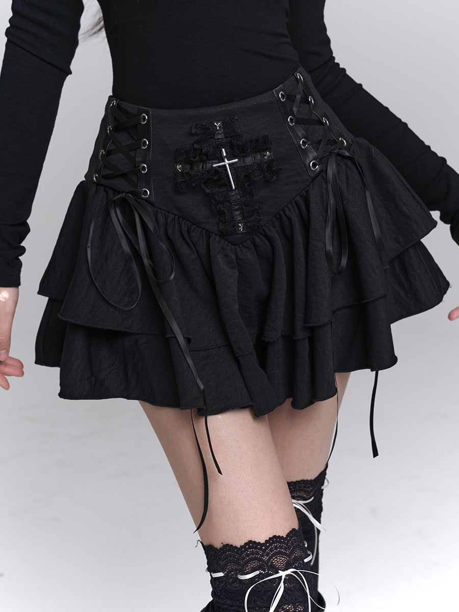 Black tiered mini skirt with corset waistband, cross applique, and ribbon ties