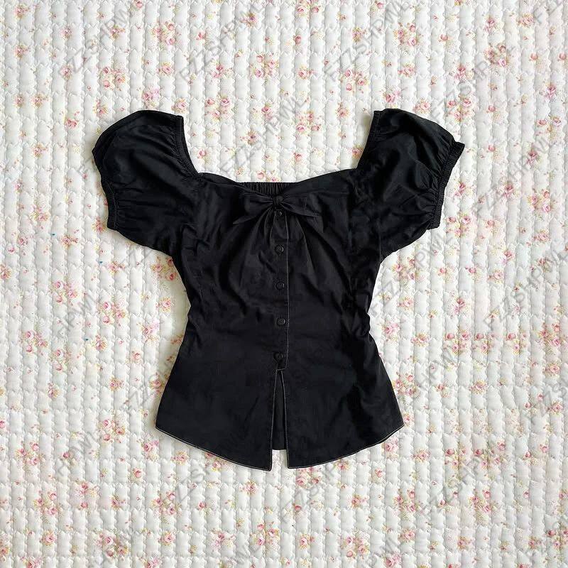 Black camisole with wide off-shoulder neckline, center buttons, gathered front, short length