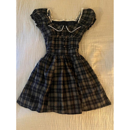 Plaid square-neck dress with puff sleeves, cream ruffled trim, gathered waist, and button bodice.