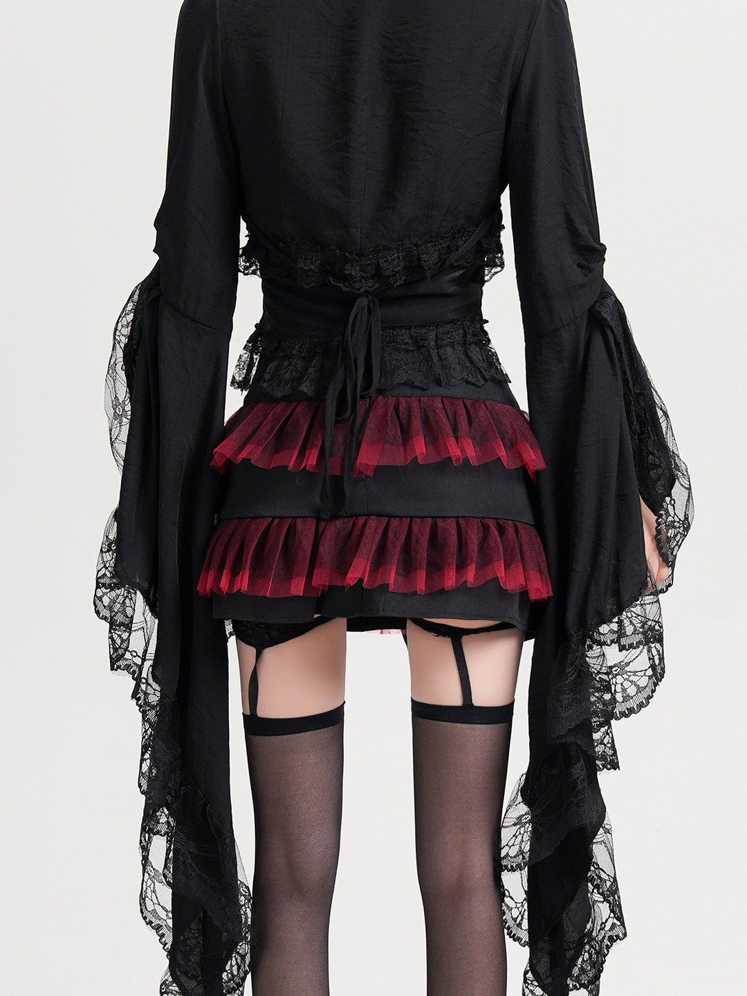 Black cropped lace coat with flared sleeves, lace cuffs, and waist tie detail.