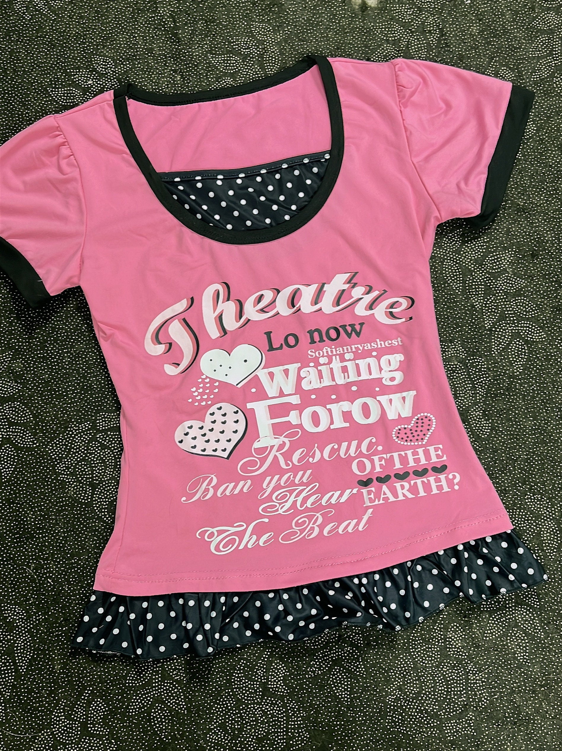 Pink youth T-shirt with black neckline trim, heart letter graphic and polka-dot ruffle