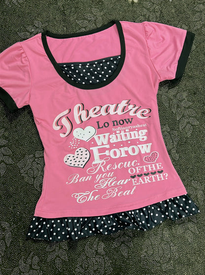 Pink youth T-shirt with black neckline trim, heart letter graphic and polka-dot ruffle