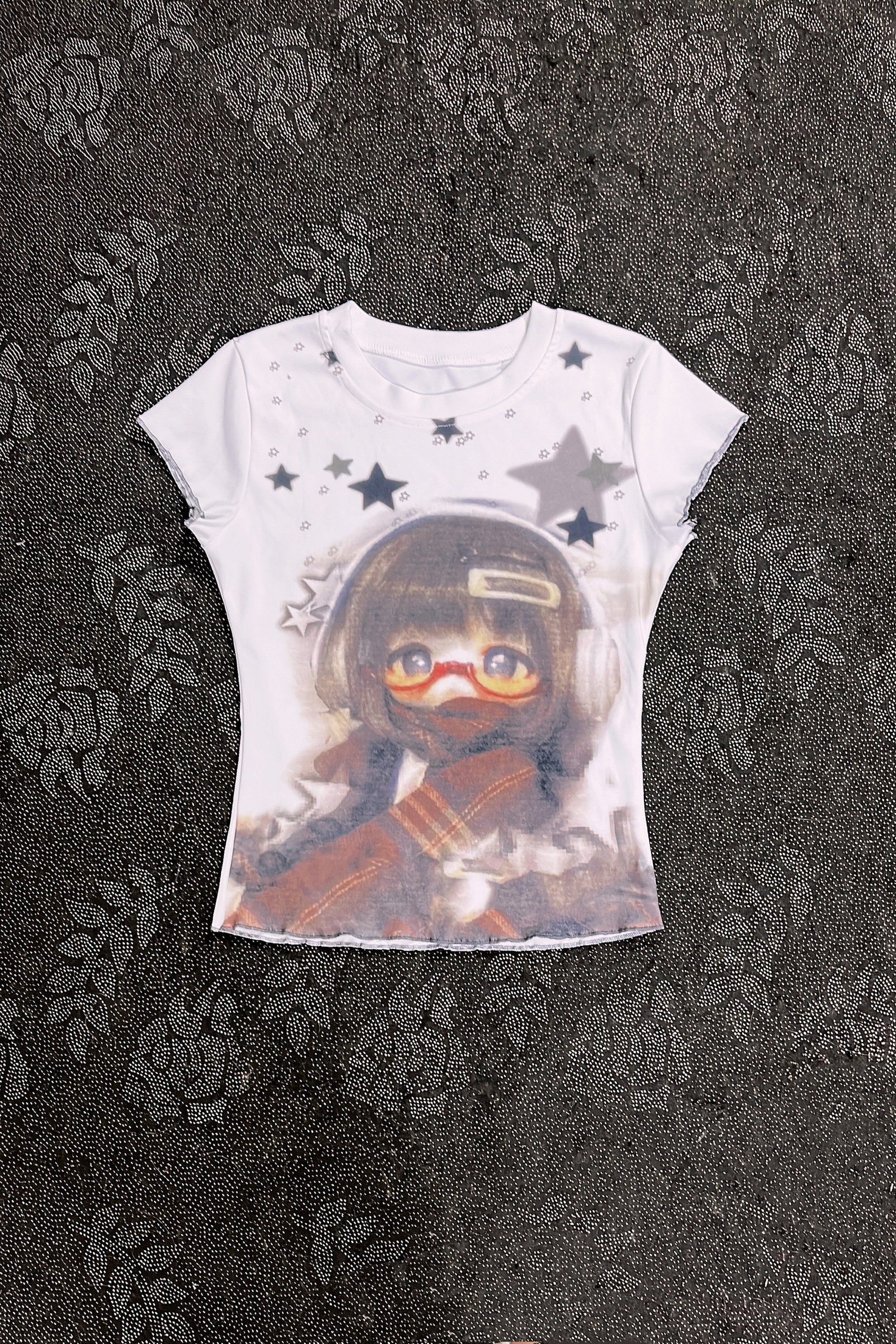 White graphic T-shirt with character portrait and gray star pattern
