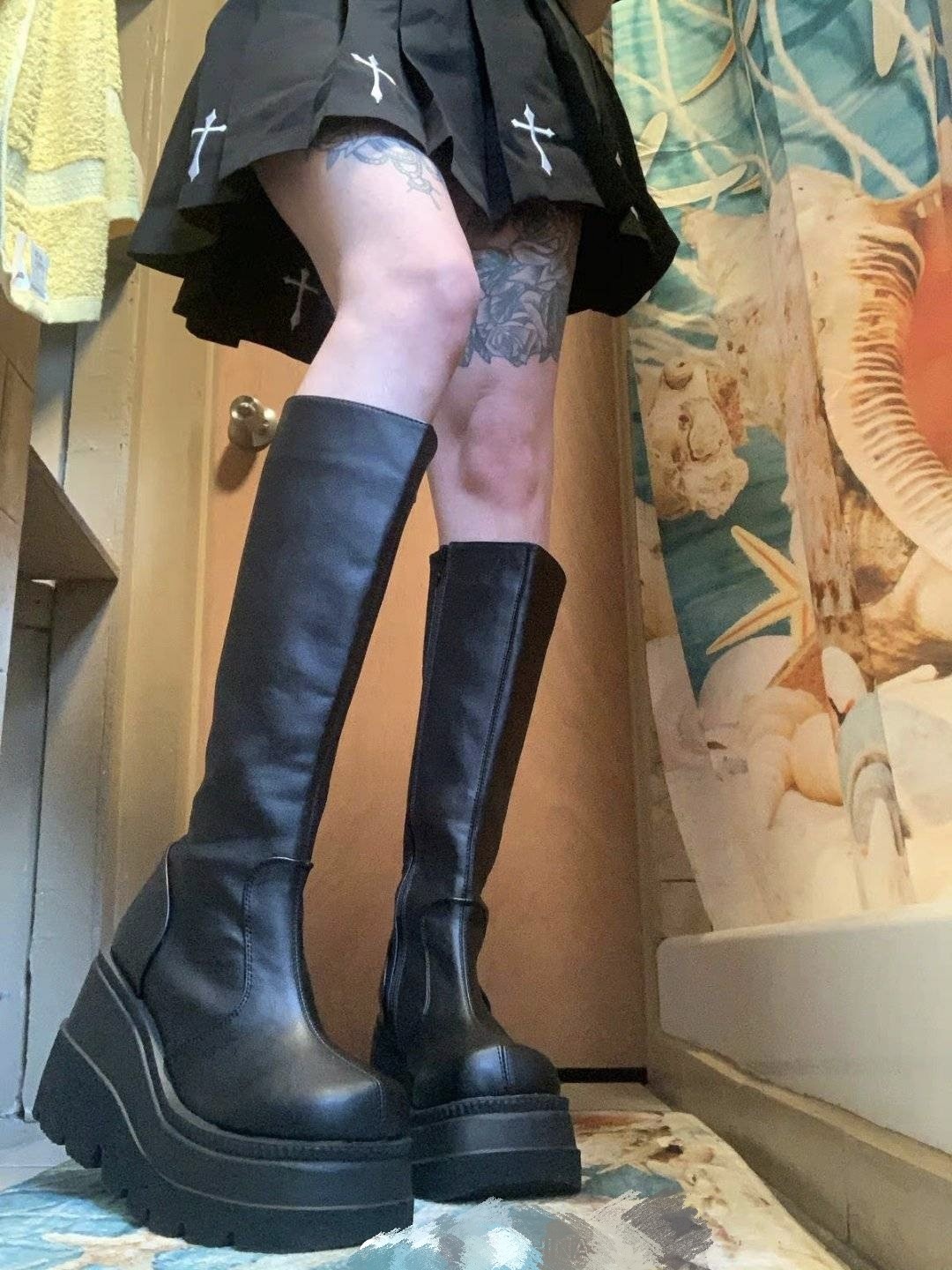 Black knee-high platform boots with side zipper, chunky sole and squared toe
