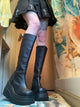 Black knee-high platform boots with side zipper, chunky sole and squared toe