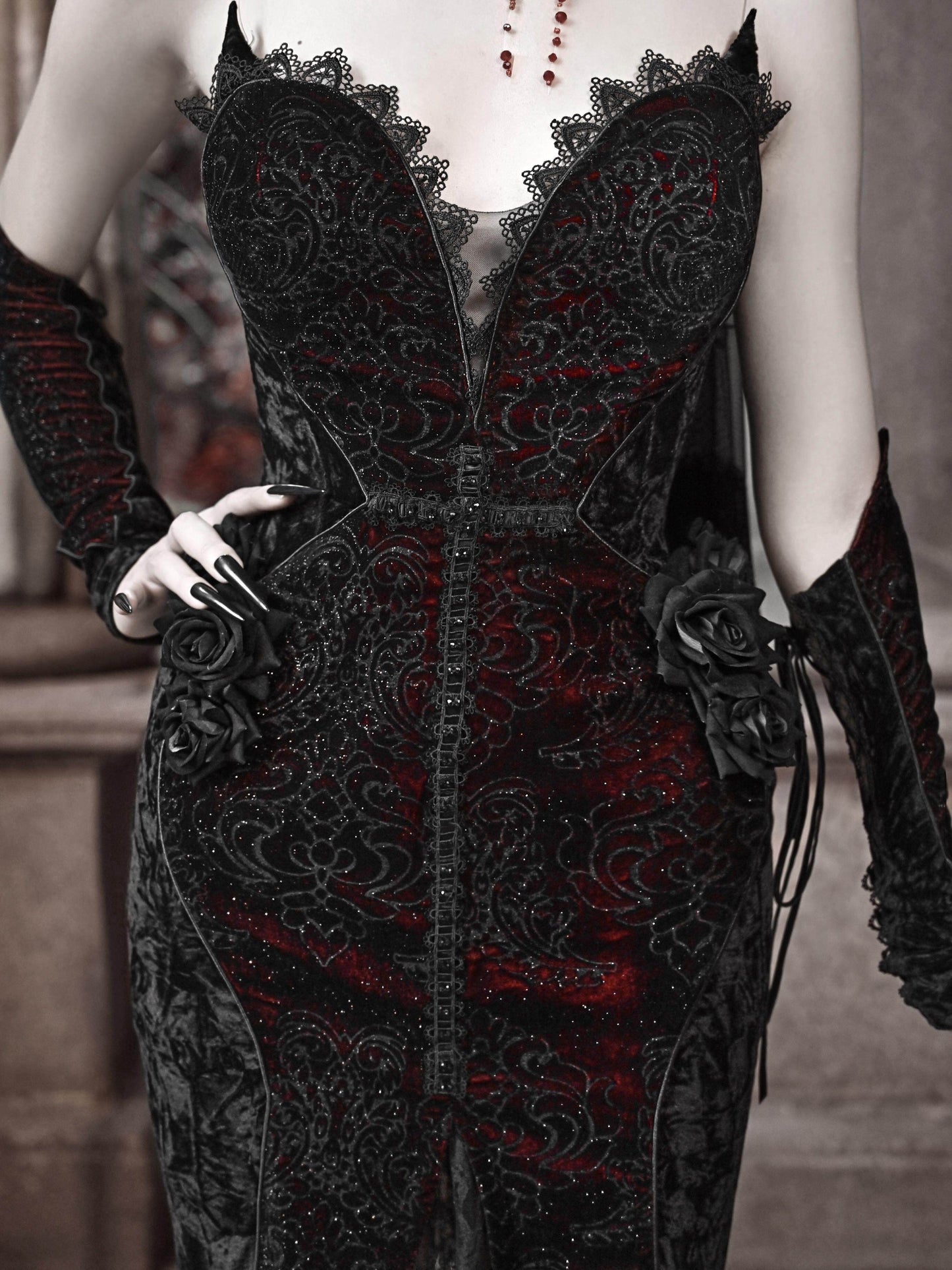 Black gothic corset dress bodice with lace trim and red accents, rose-like applique details.