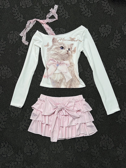 Cream long-sleeve top with cat graphic, lace-trim strap, and layered pink ruffle skirt