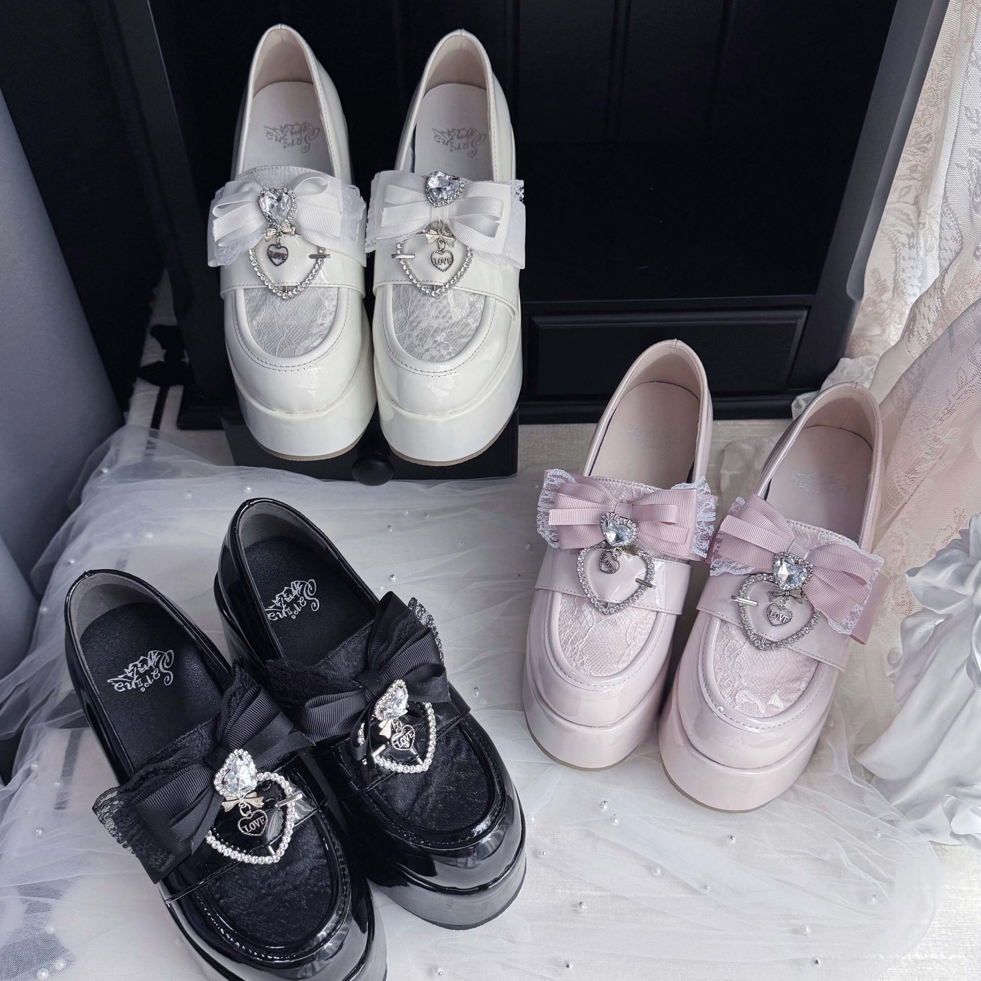 White platform loafers with bow and heart charms, with light pink matching pair
