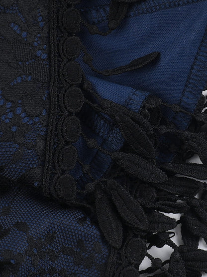 Jacquard fabric close-up with dark textured pattern and black tassel edging