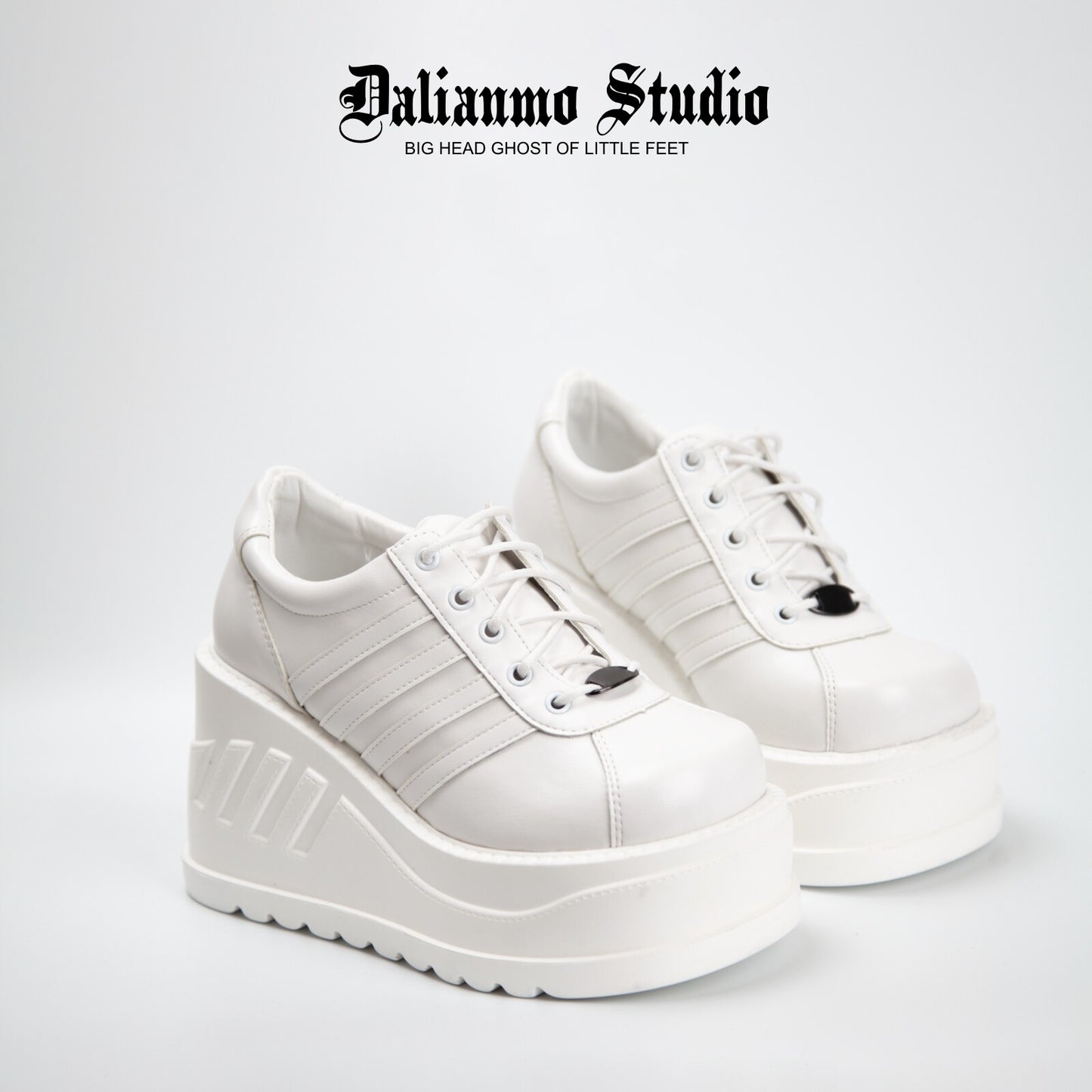 White platform lace-up sneakers with three stripe panels and thick tread sole