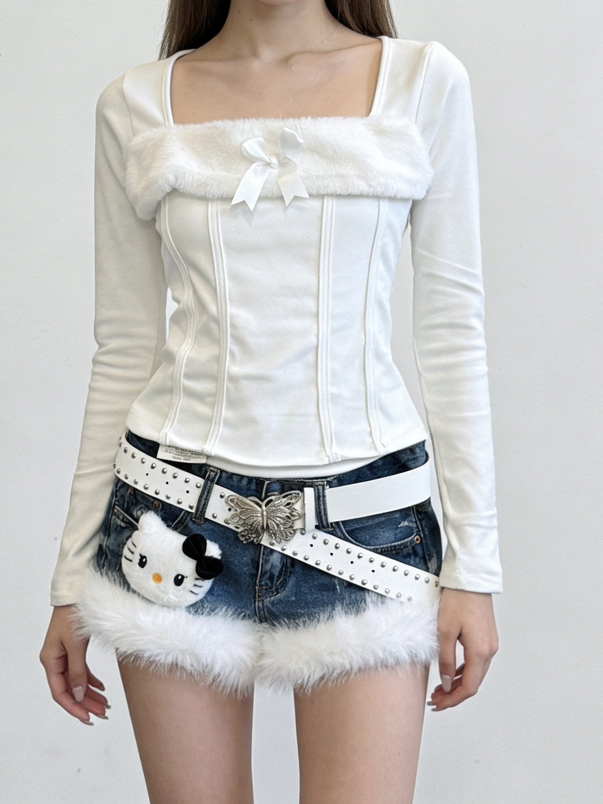 White faux-fur denim shorts with studded belt and cat charm