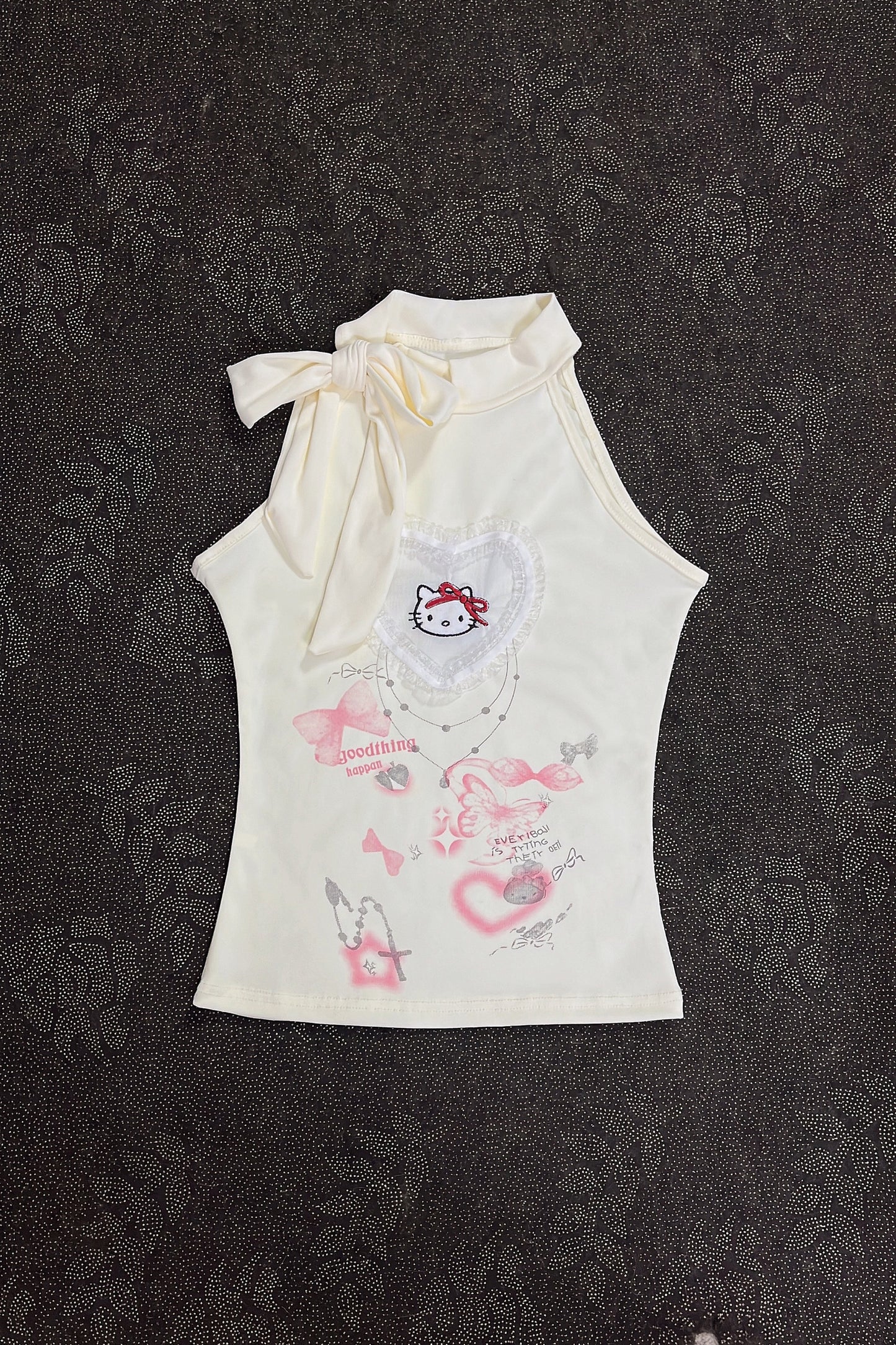 Cream sleeveless girls top with ribbon bow neckline and kitty heart graphic