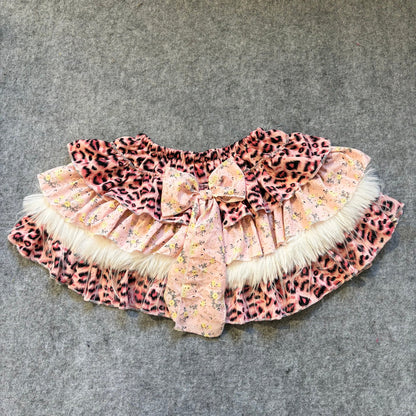 Puffy mini skirt in leopard print with light floral accents, faux fur trim and bow