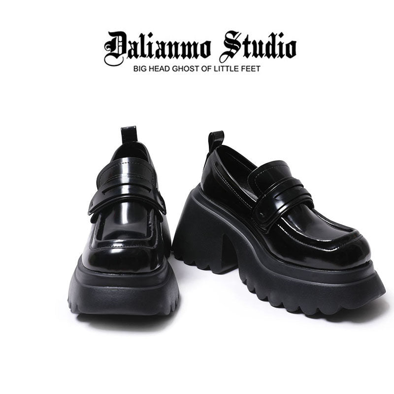 Black platform loafers shown front and back, with thick treaded sole and glossy upper