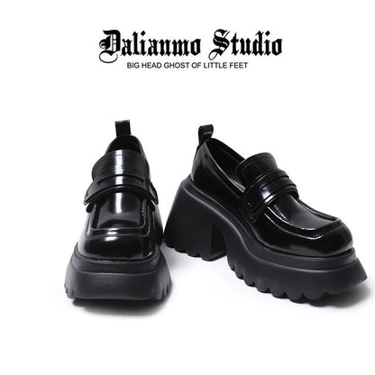 Black platform loafers shown front and back, with thick treaded sole and glossy upper