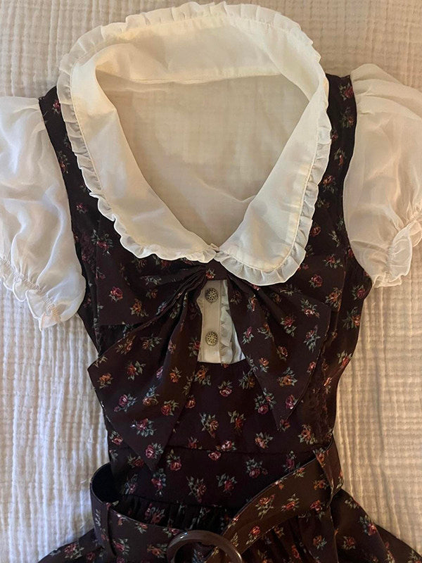 Floral doll collar shirt dress detail view, dark brown fabric with floral print, bow and buttons