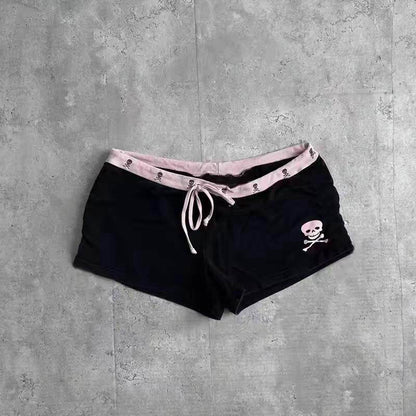 Black shorts with pink striped waistband, skull graphic, and tied drawstring