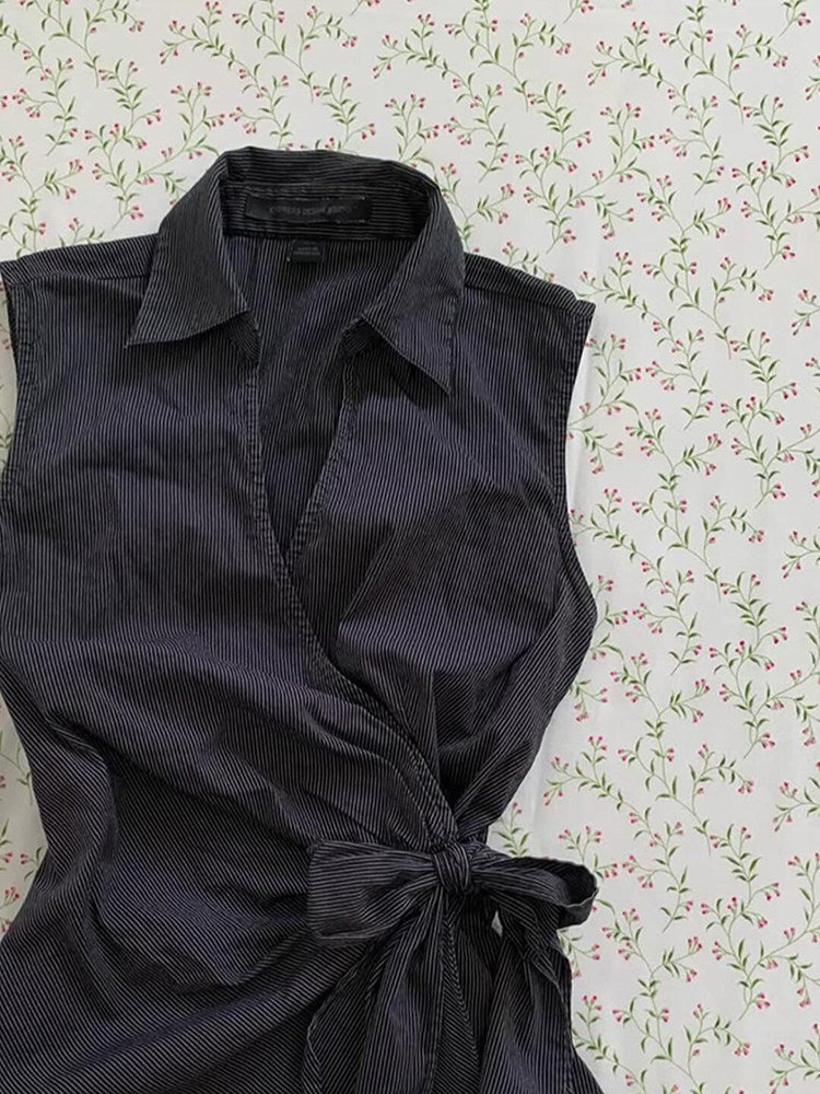 Black sleeveless cardigan top with open V-front and pointed collar, waist tie bow