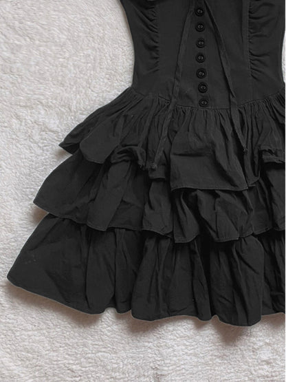 Black tiered ruffle skirt of cake dress with gathered layers and buttoned bodice