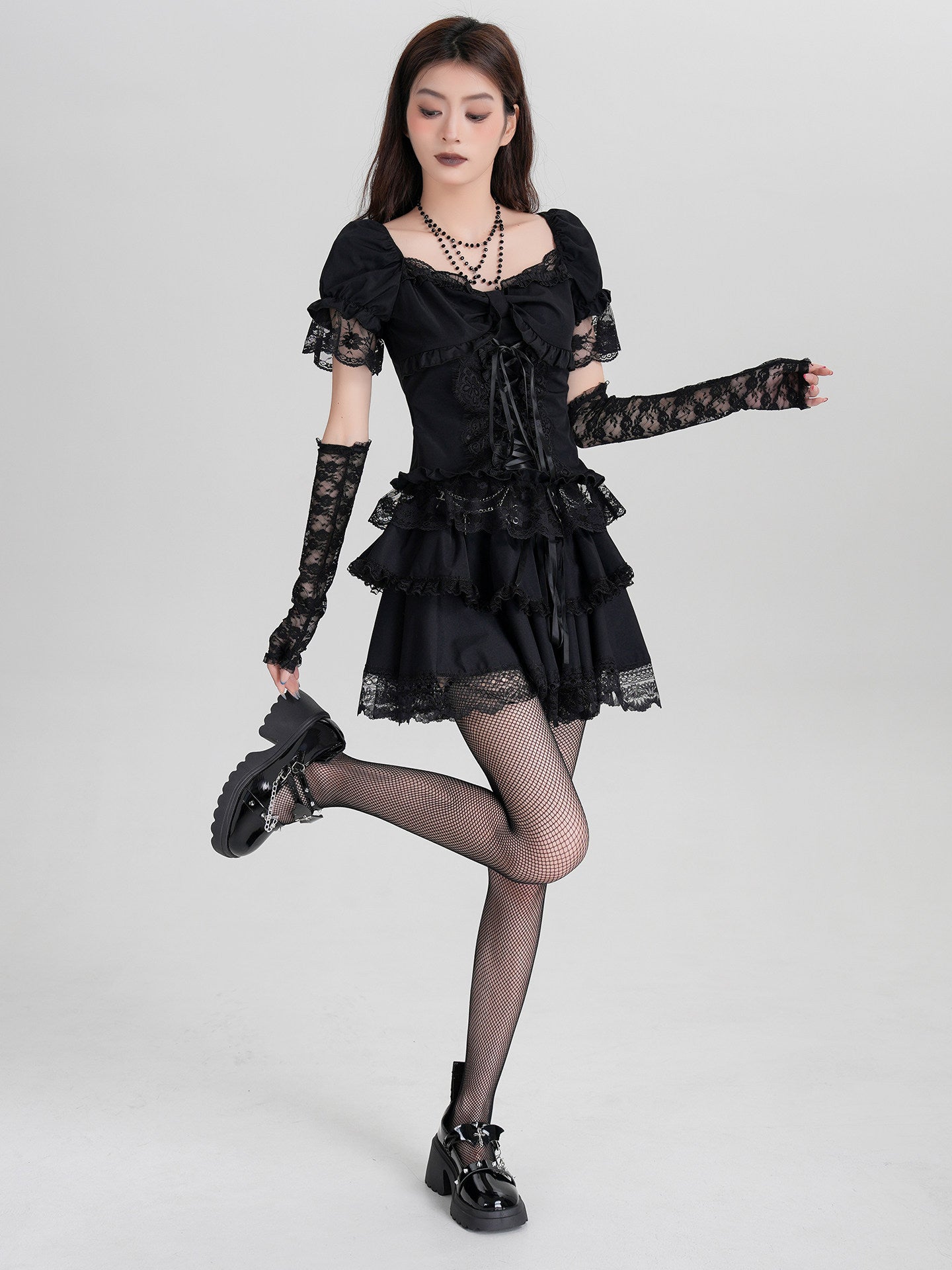 Black off-shoulder ruffle mini dress with lace arm warmers and corset-lace front