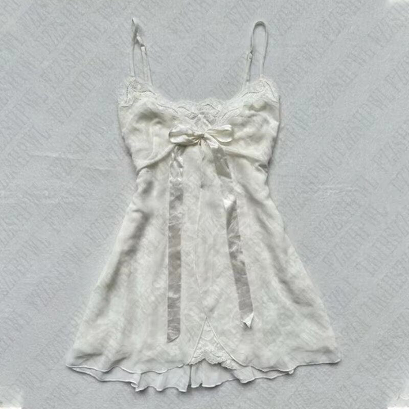 White satin slip dress with bow at bust and lace-trimmed ruffled hem
