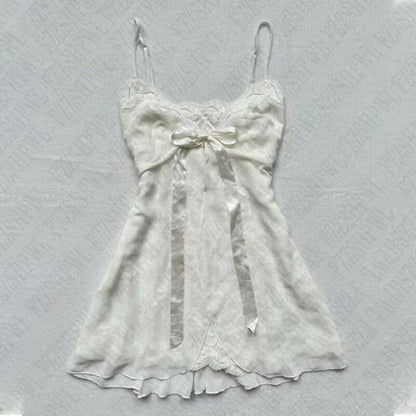 White satin slip dress with bow at bust and lace-trimmed ruffled hem