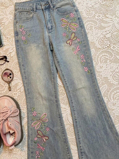 Light blue jeans with butterfly embroidery on upper right thigh and lower leg.
