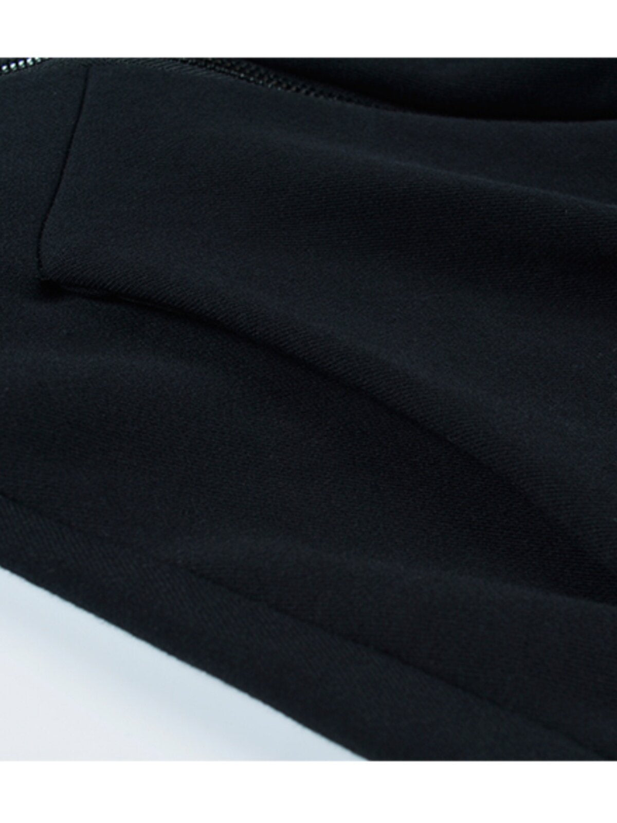 Black hooded sweater fabric close-up with stitched seam and hem