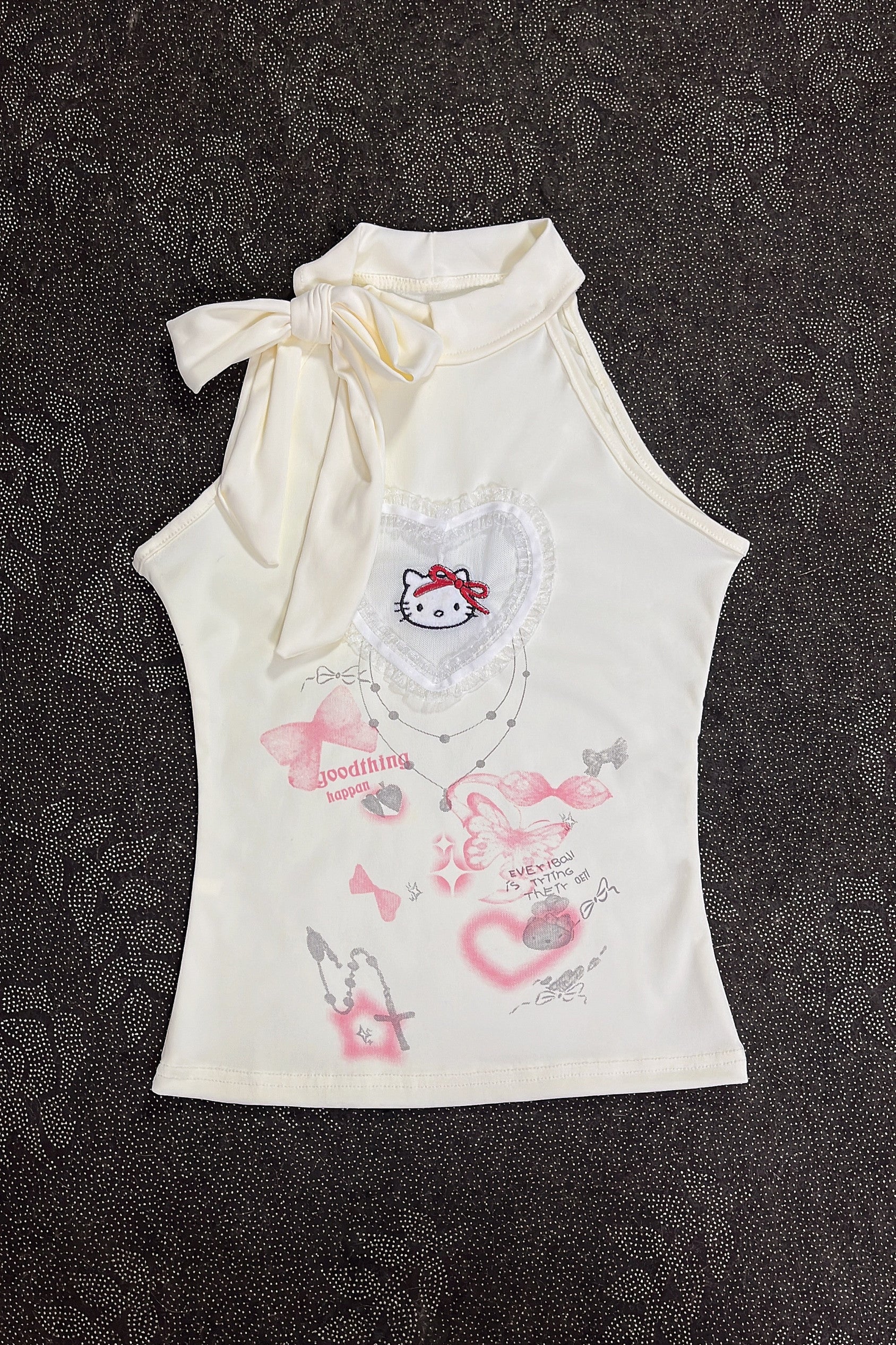 Cream sleeveless girls top with knot bow at neck and pastel kitty print