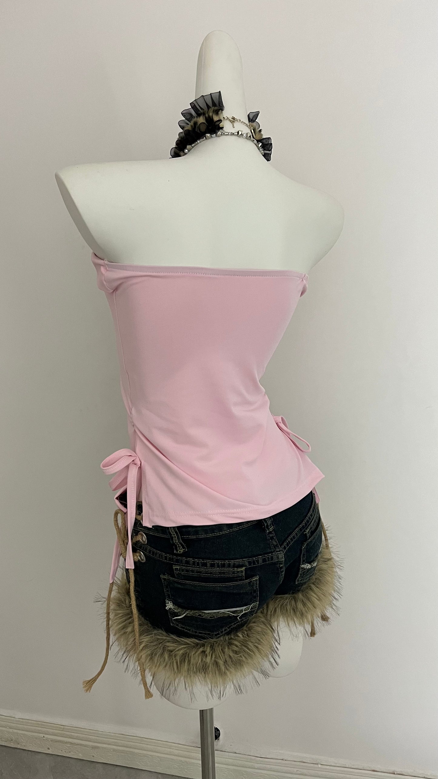 Pink strapless corset top with tied side bows and black beaded neckline