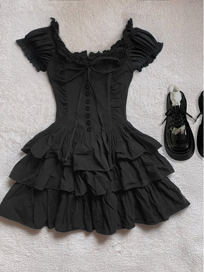 Black ruffled cap-sleeve cake dress with bow detail and stacked tier skirt