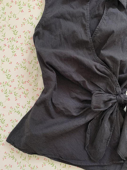 Black sleeveless cardigan top with tied waist bow and subtle pinstripe texture