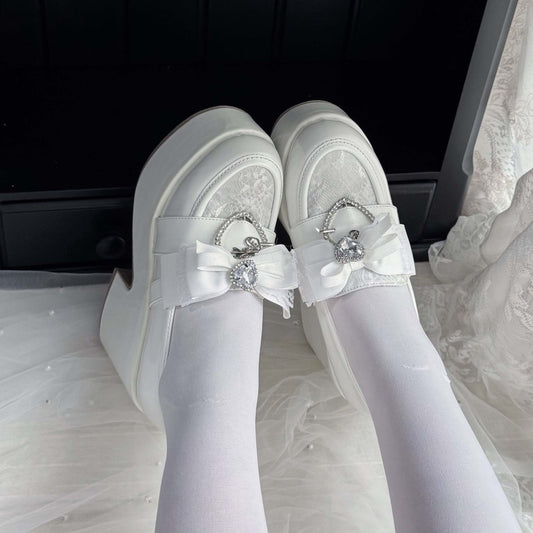 White lace platform loafers with ribbon bow and jeweled heart charm accents