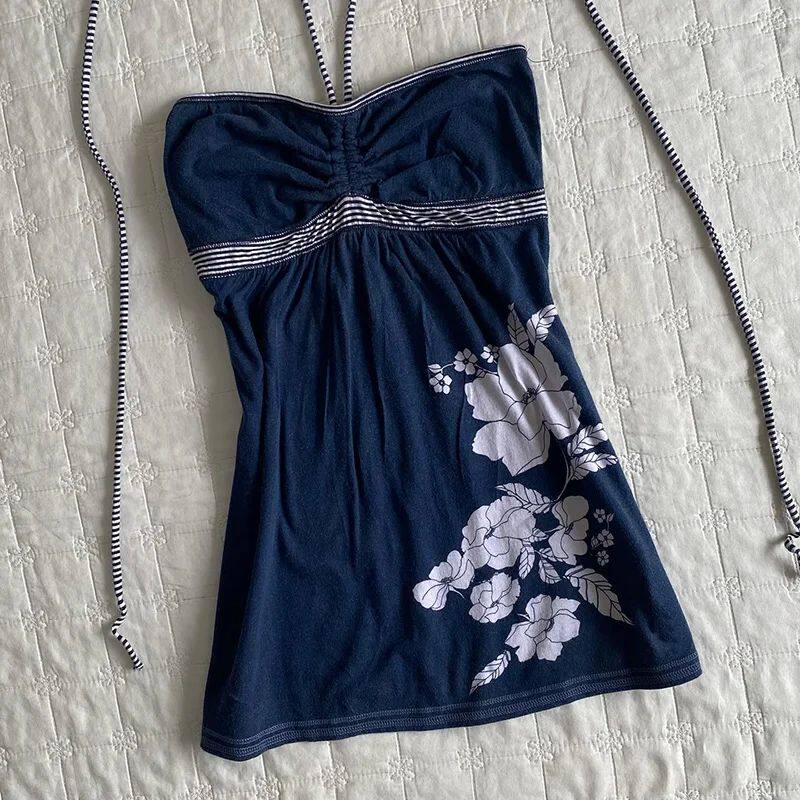 Navy bandeau dress with white floral print, striped elastic band, and tie straps