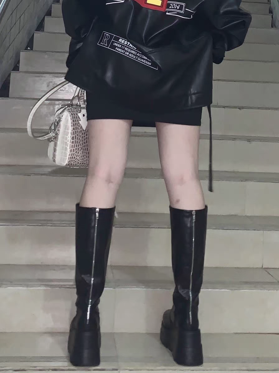 Black knee-high boots with glossy finish, side zippers, and thick platform sole