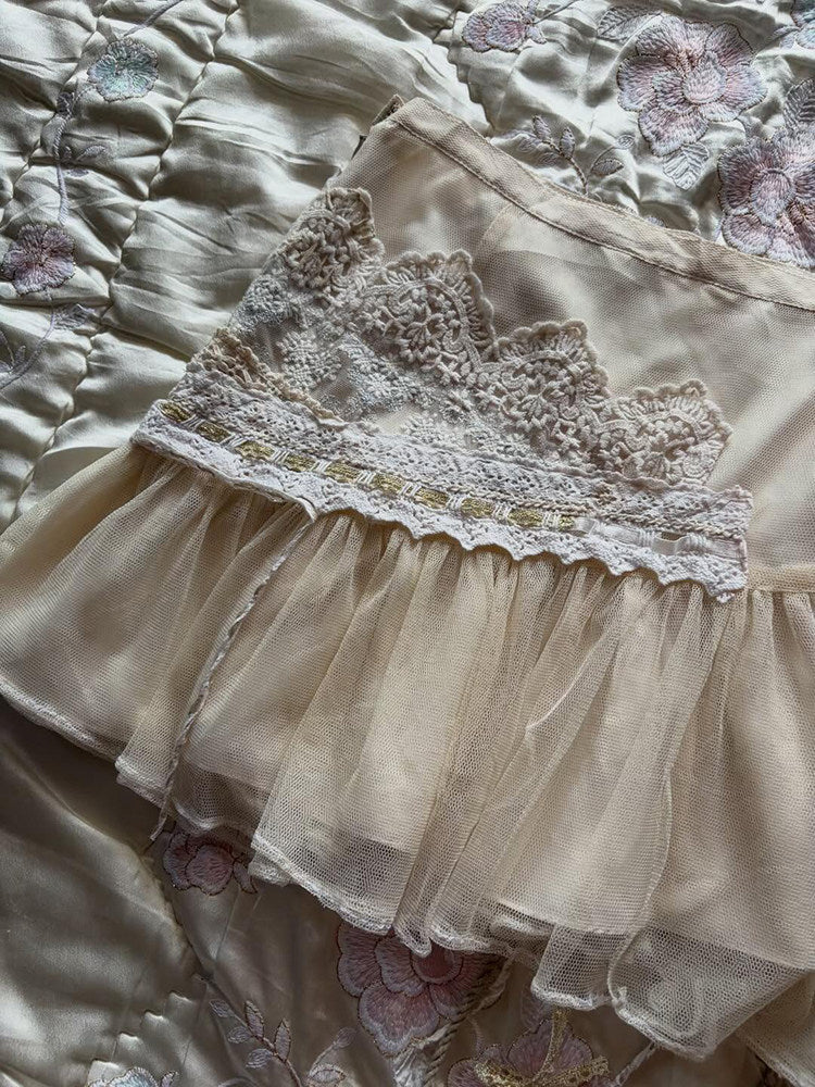 Apricot-toned lace midi skirt close-up: embroidered lace yoke and scalloped trim
