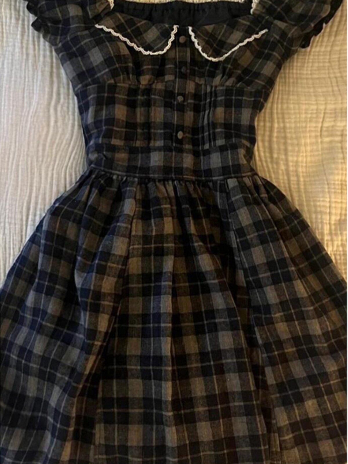 Plaid square-neck dress with gathered waist and full skirt; button front and ruffled cream trim.