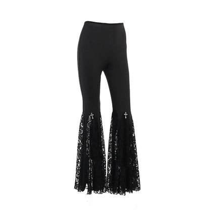 High-rise black pants with lace bell-hem panels and cross-like embroidery at the flare