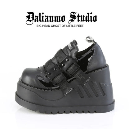 Black platform shoes with double buckles, textured paneling, and thick tread sole