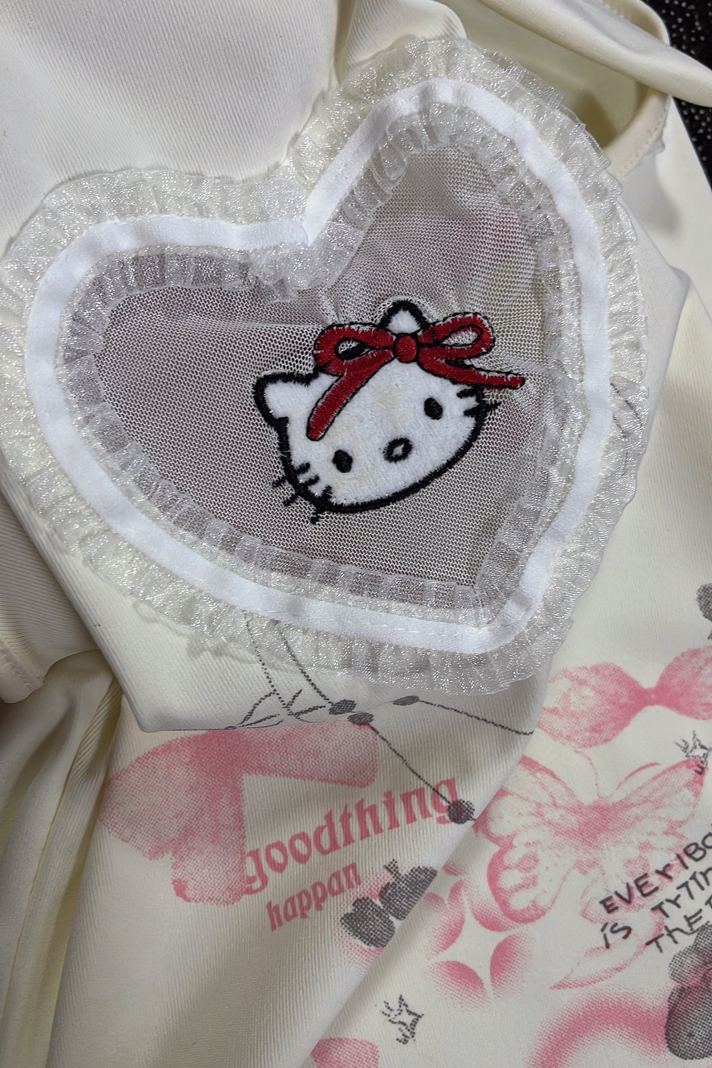 Hello Kitty heart patch with red bow on cream sleeveless top