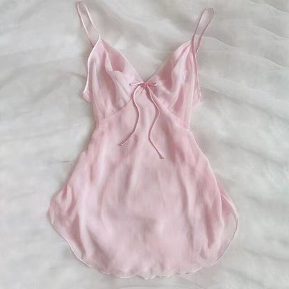 Light pink satin slip dress with spaghetti straps and bow-tied neckline