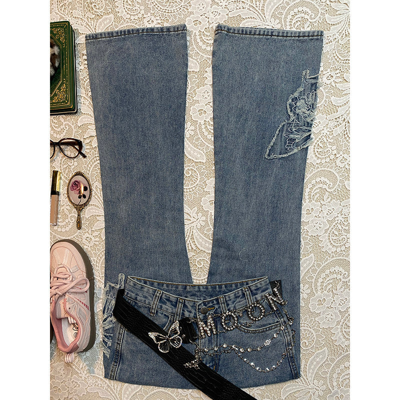 Light-blue micro-flare denim jeans with butterfly patches and embellished waistband